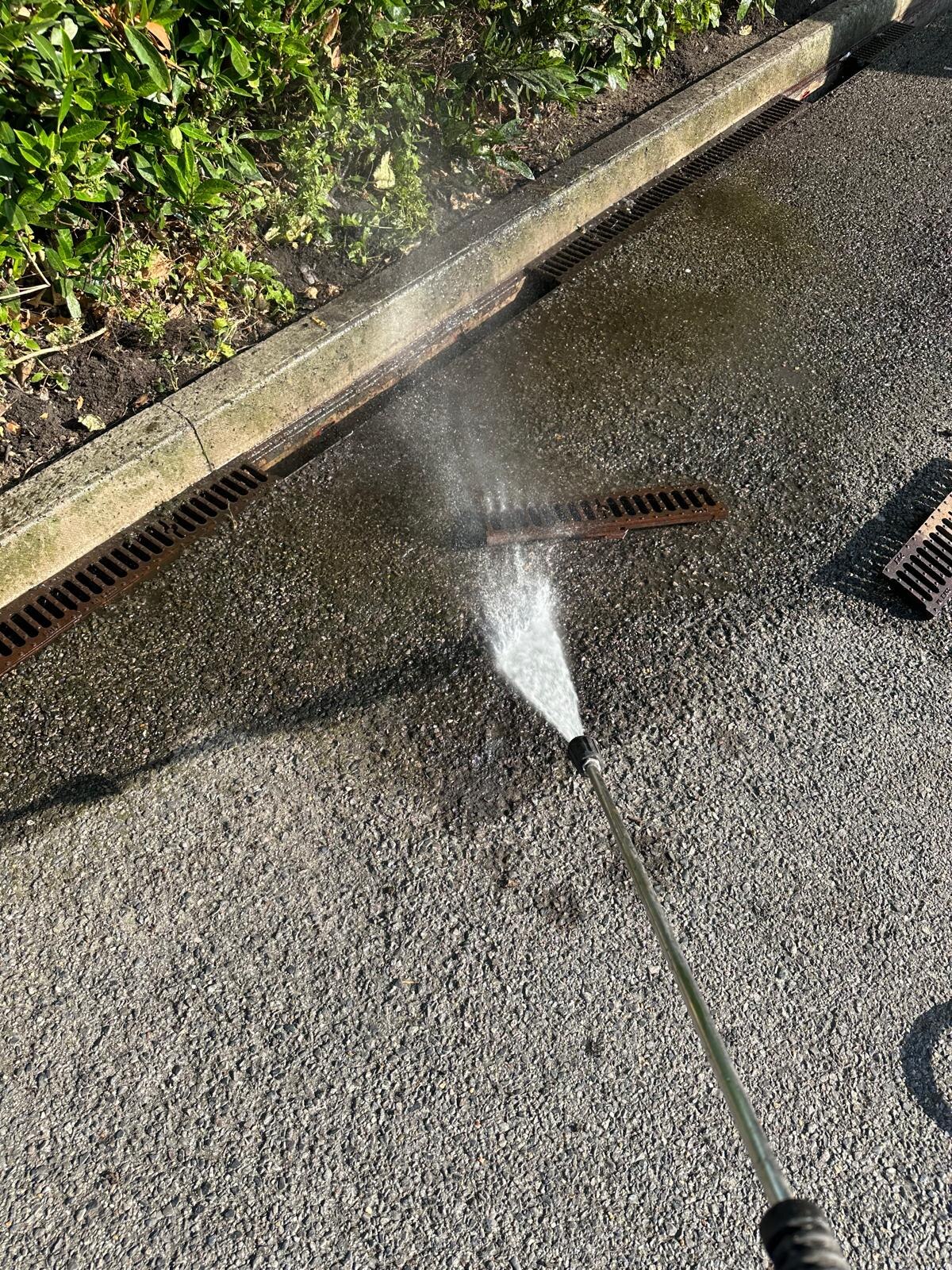 High-pressure drain jetting clearing a channel drain