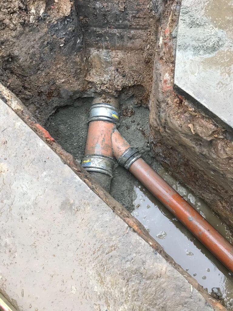 Underground drain pipe junction repair in trench