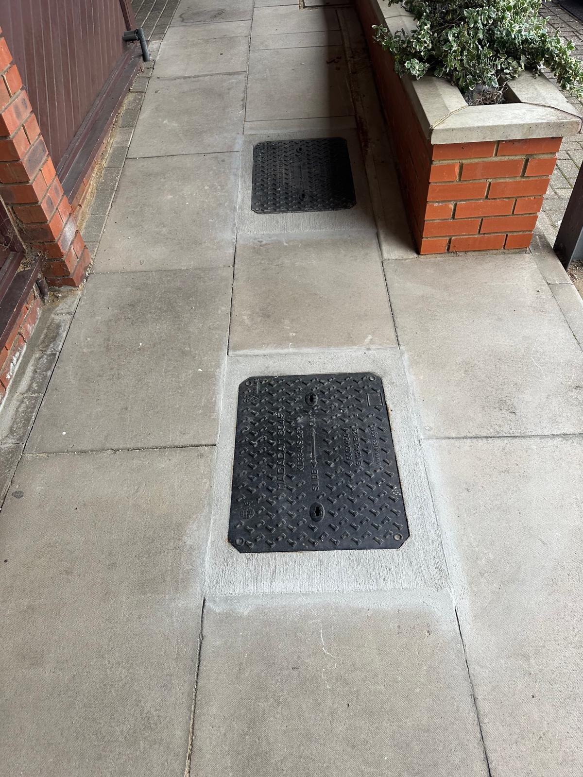 New manhole covers installed in paved walkway