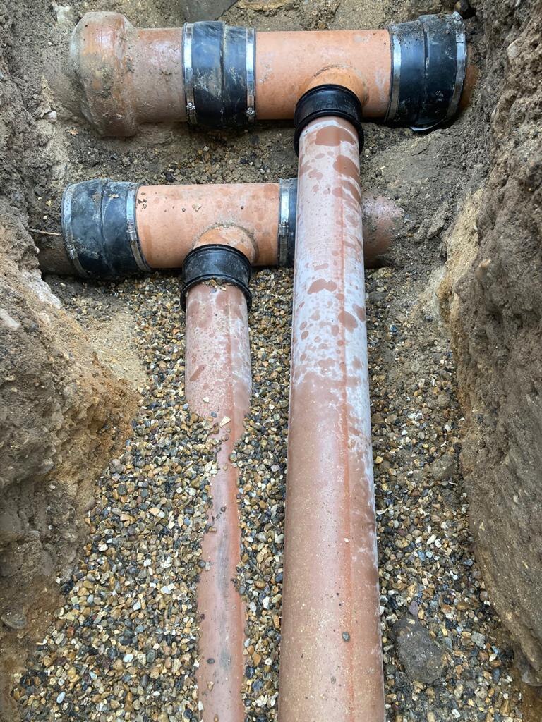 Underground drain pipes laid in pea shingle